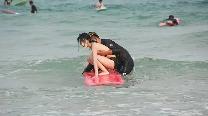 สาวเล่นเซิร์ฟริมหาด ถูกคลื่นซัดบิกินี่หลุด โค้ชรีบคว้าช่วย กลายเป็นดราม่าร้อน !